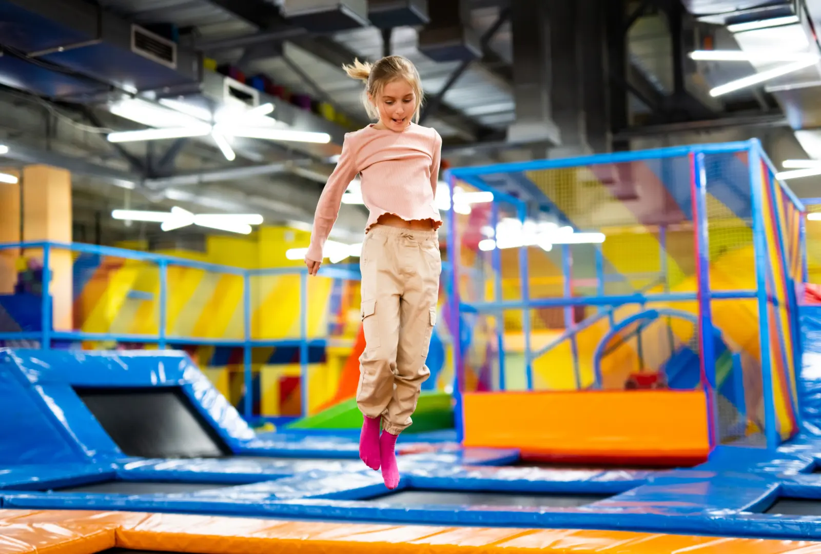 dievča skáče na trampolíne v interiérovom detskom parku Dinopark Nové Zámky